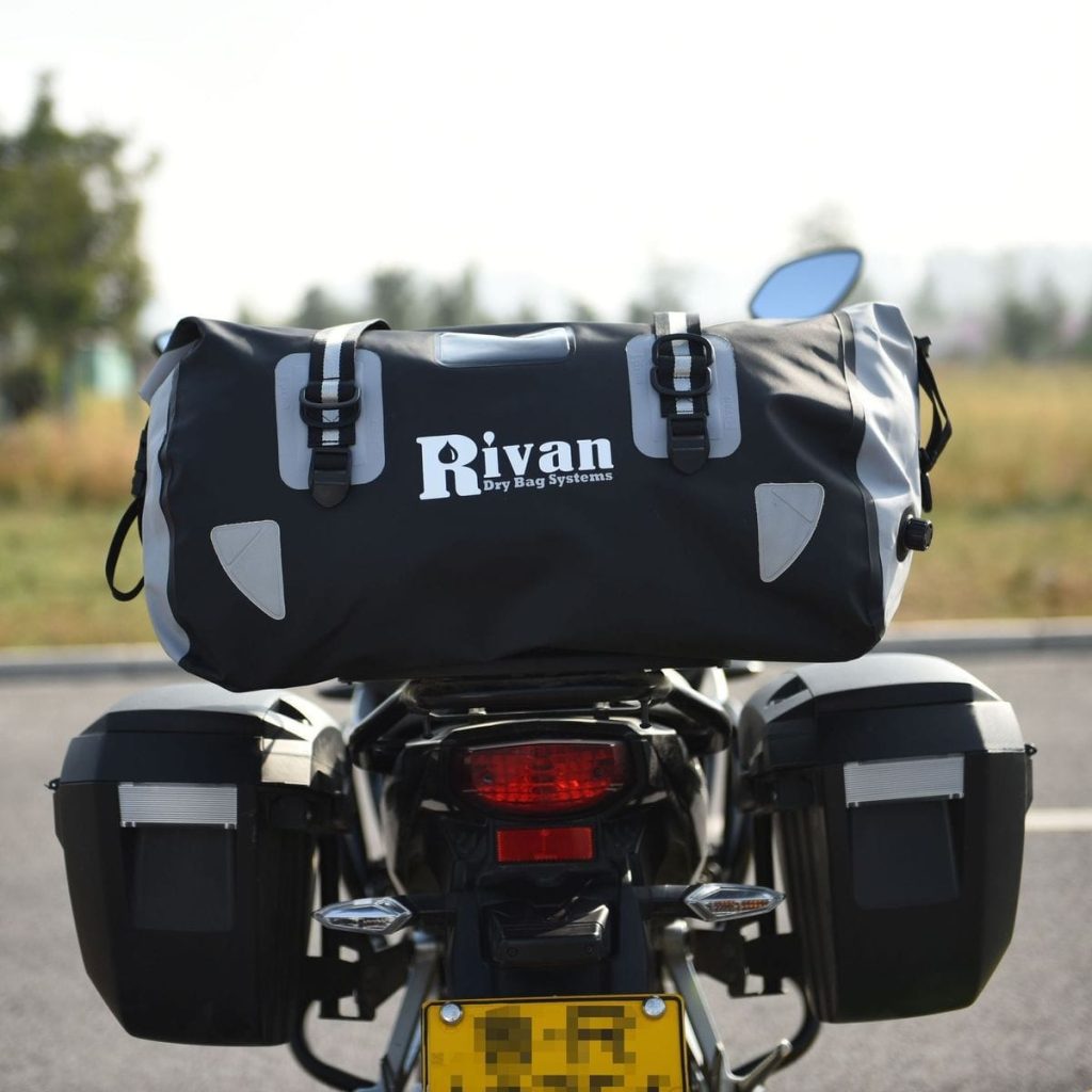 Sac étanche moto 60L Rivan, PVC noir et gris, fermeture par enroulement, vue arrière sur moto